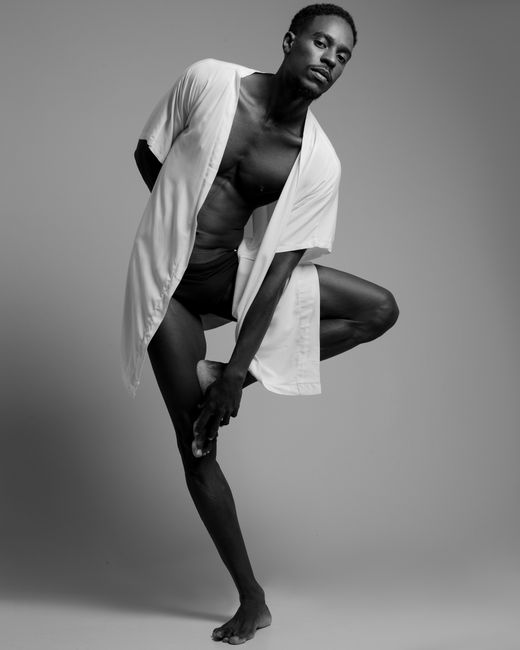 Elegant studio capture of a man posing gracefully, highlighting movement and form.