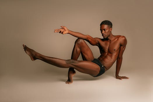Artistic studio portrait of a shirtless athletic man posing creatively.