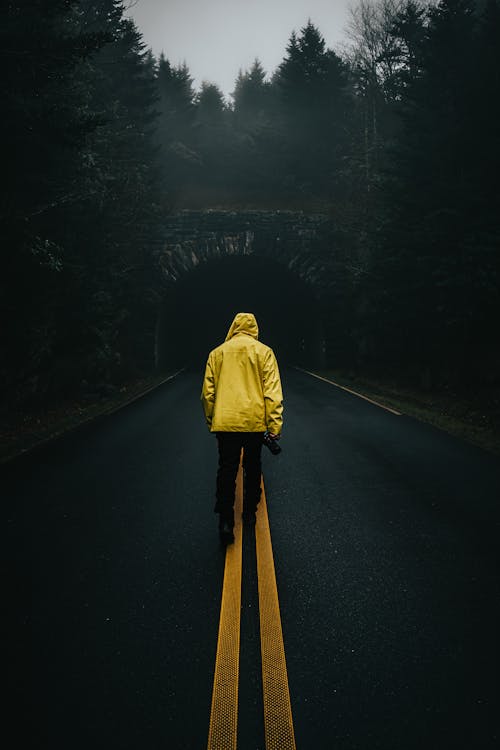 A Man in Yellow Jacket Standing on the Road