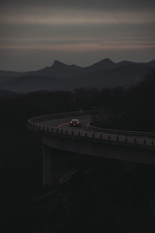 Car Driving on an Elevated Road in Mountains 