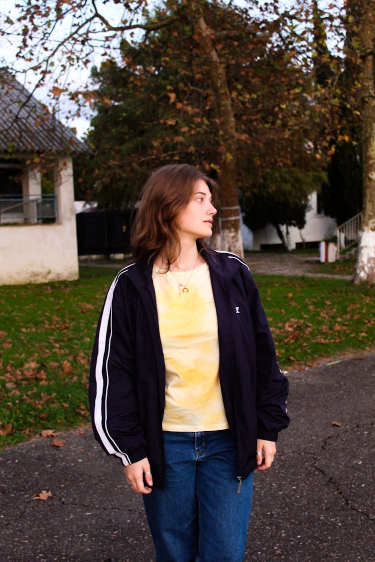 Girl In Casual Clothing Standing On A Sidewalk 