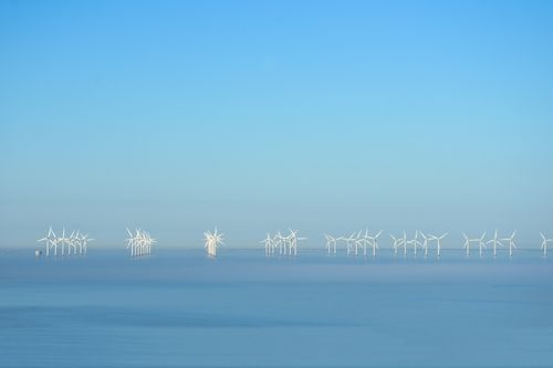 Free Serene offshore wind turbines beneath a clear blue sky generating renewable energy. Stock Photo