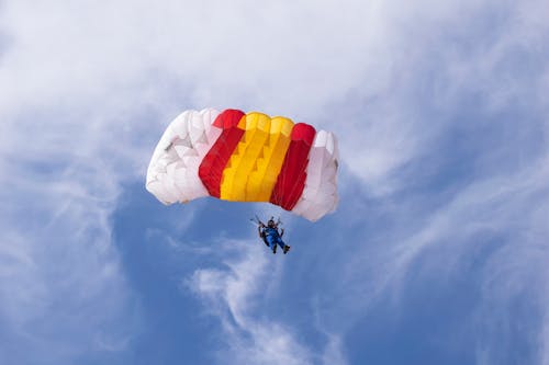 Low Angle Shot of a Man Falling with a Parachute 