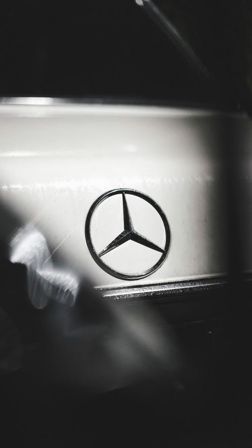 Free Elegant black and white photo featuring a close-up of a famous car emblem with sleek design. Stock Photo