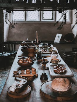 A cozy, rustic kitchen scene featuring bread and fresh ingredients on a wooden table.