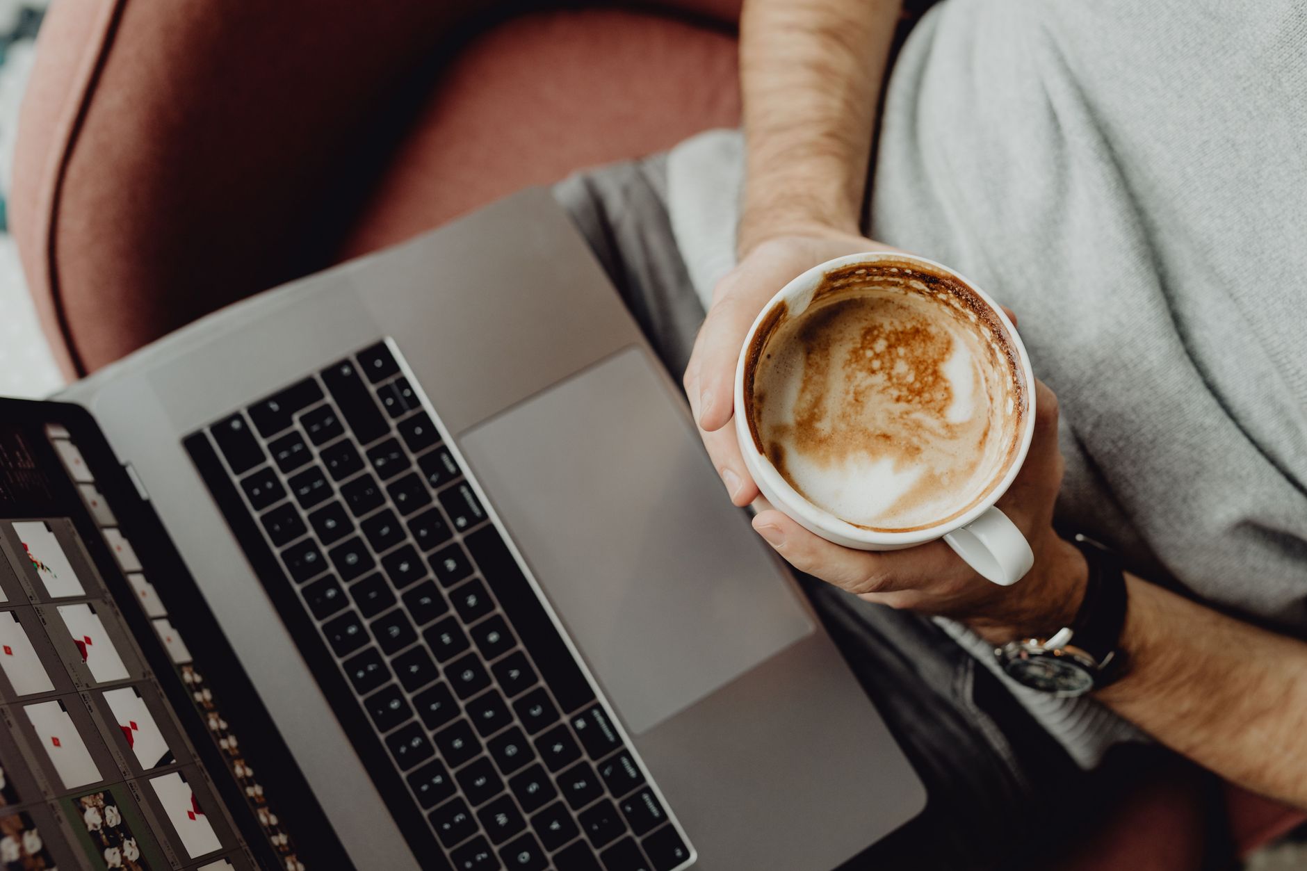 A person relaxing with a latte and laptop, top view on a comfortable chair. Perfect freelance vibe.