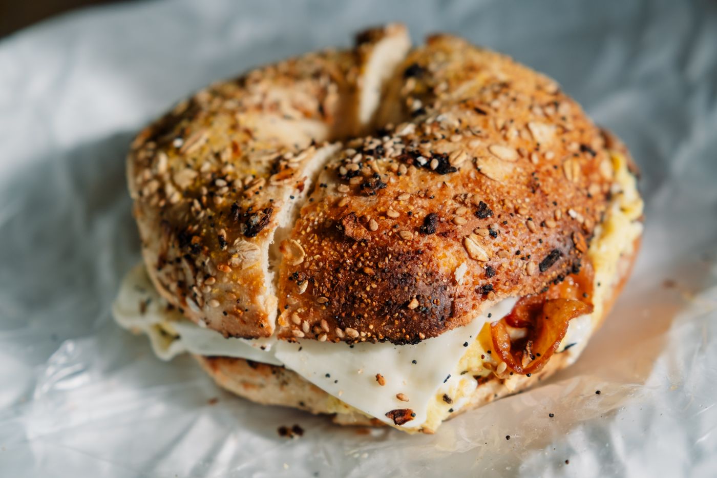 Bagel ai semi farcito con uovo, formaggio e bacon