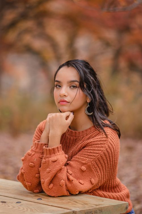 Free Elegant portrait of a woman sitting outdoors in autumn, wearing a cozy sweater in Des Moines. Stock Photo