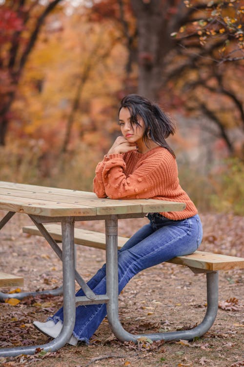 Woman Sitting on Wooden Bench in a Park