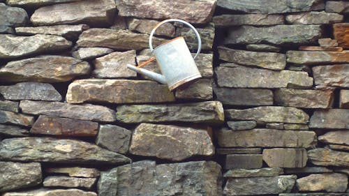 bahçıvan kovası, taş duvar, taşlar içeren Ücretsiz stok fotoğraf