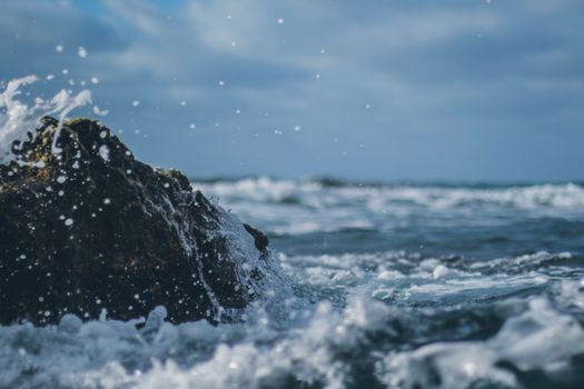 Photograph of Water Crashing on a Rock