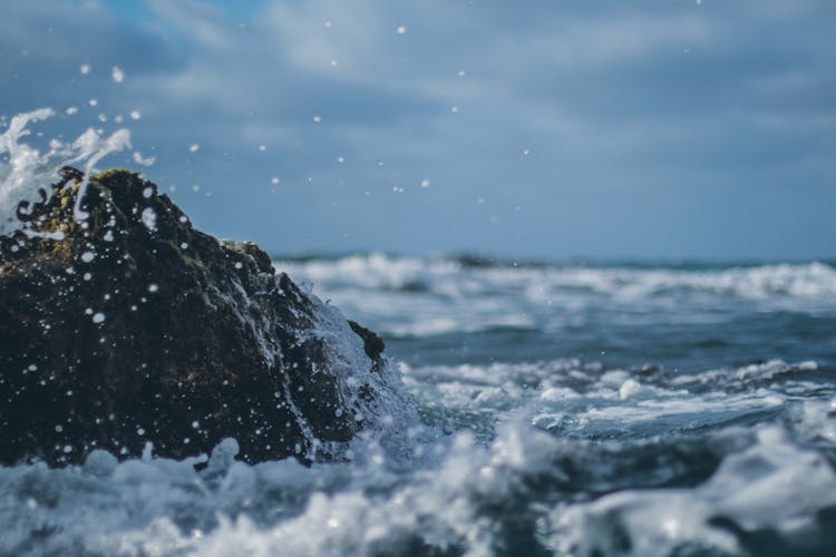 Photograph Of Water Crashing On A Rock