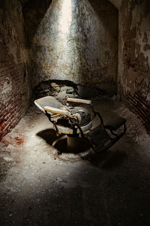 Free Eerie scene of a broken chair in an abandoned Philadelphia basement, highlighting decay. Stock Photo
