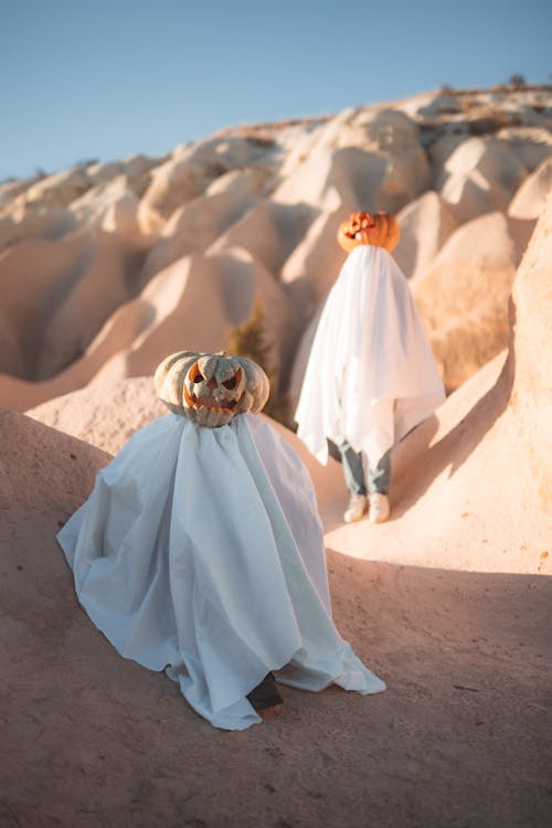 People Wearing White Sheets and Carved Pumpkins