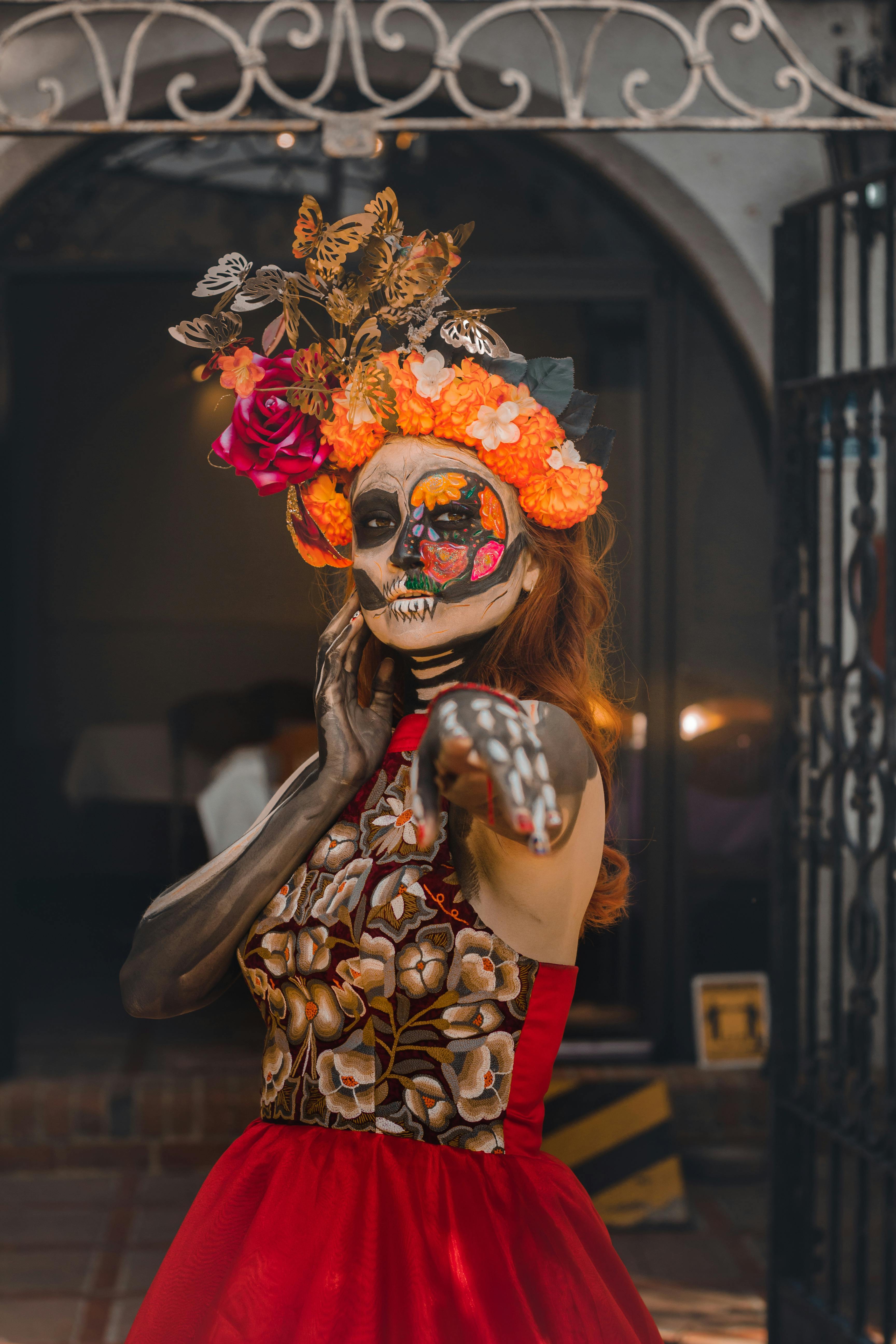 A woman dressed in vibrant Day of the Dead attire with intricate makeup, celebrating in Mexico City.