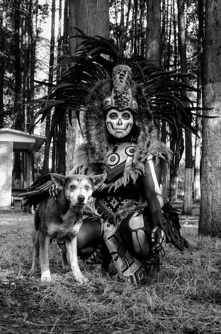 A Man In A Costume And A Dog In The Forest