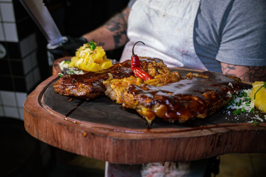 Baby back ribs glazed with barbecue sauce on a wooden platter