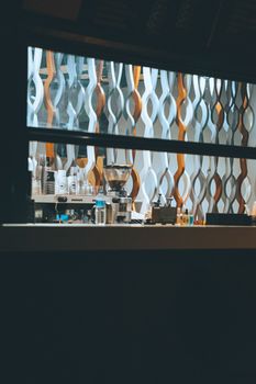 A stylish coffee shop interior seen through a window, illuminated at night.