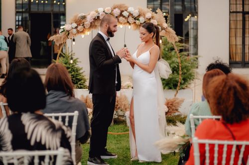 Free Bride and groom exchange vows in a picturesque outdoor setting. Perfect moment captured. Stock Photo