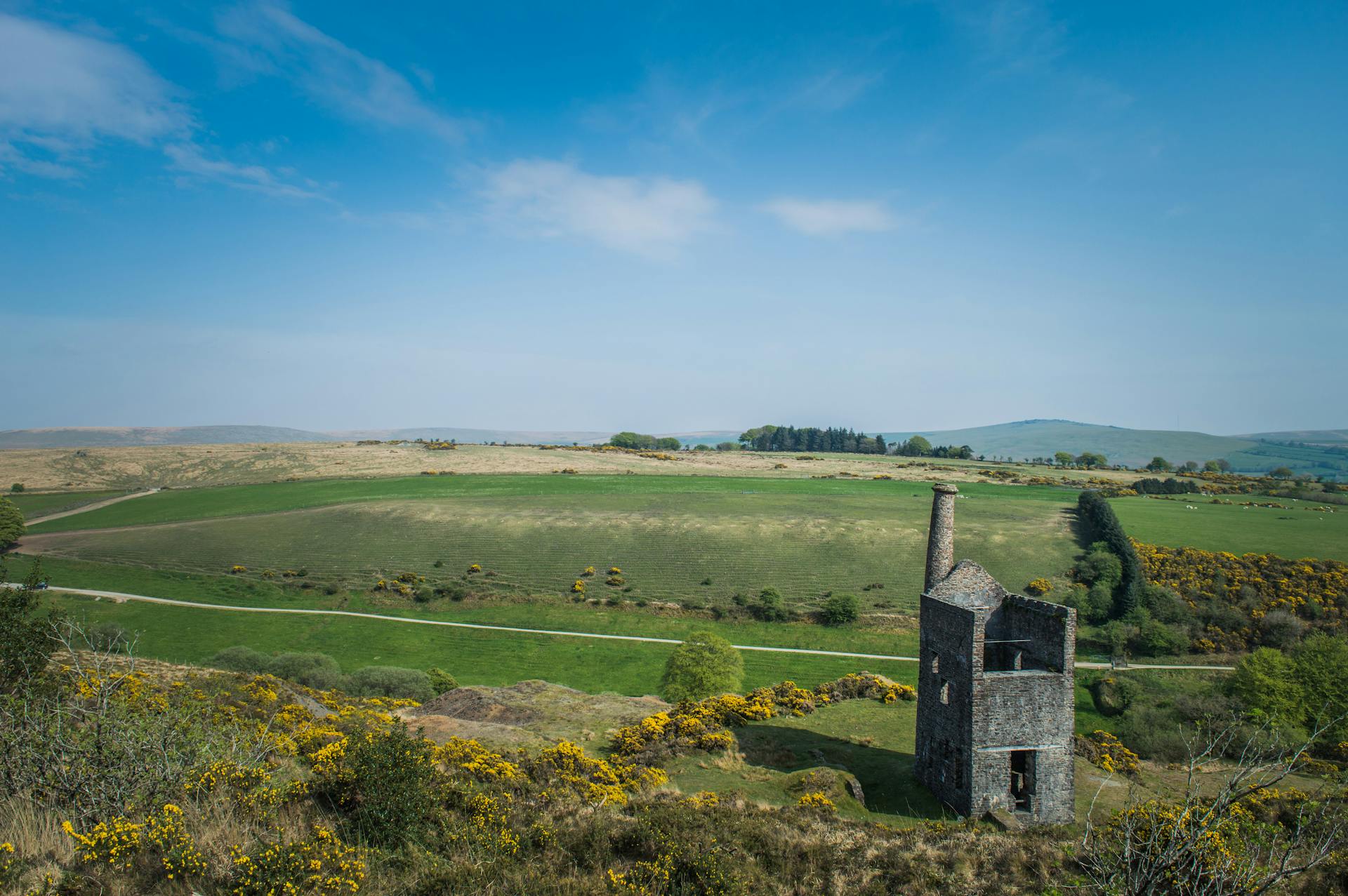 Aerial view of Wheal Betsy mining ruins amidst the scenic landscapes of Dartmoor, England.