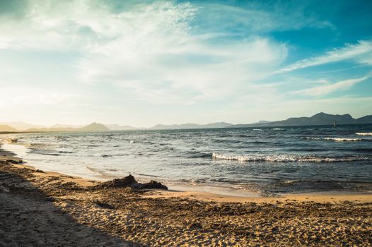 Experience the serene beauty of Can Picafort beach, featuring golden sands and a tranquil blue sea under a bright summertime sky.