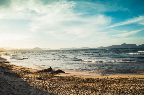Free Experience the serene beauty of Can Picafort beach, featuring golden sands and a tranquil blue sea under a bright summertime sky. Stock Photo