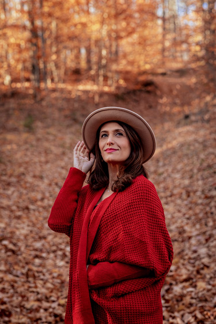 A Woman In Red Robe Wearing Beige Hat