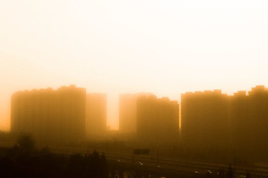 City buildings silhouetted against a golden sunrise, creating an ethereal urban scene.