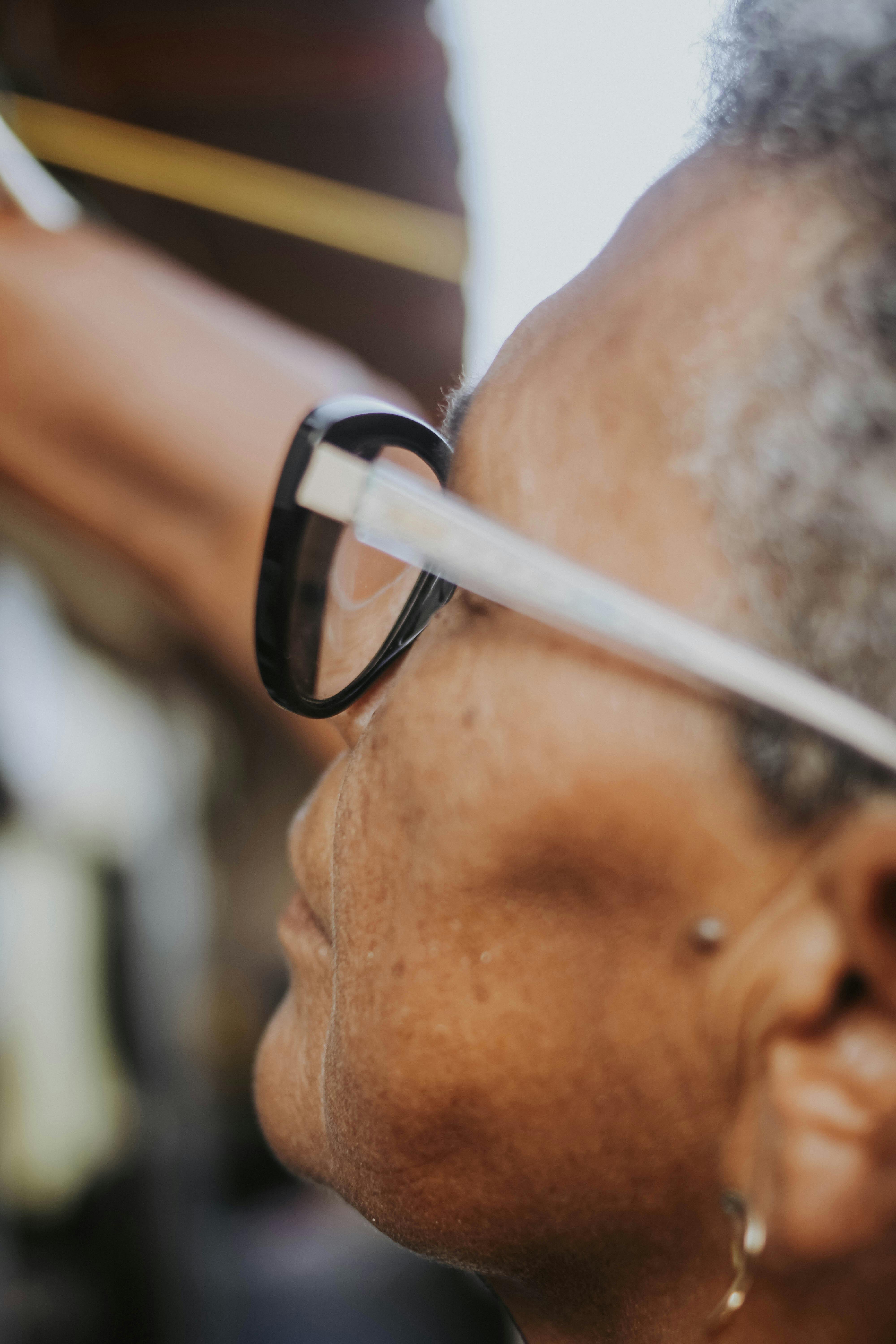 Detailed close-up of an elderly woman wearing glasses, focusing on her face and eyeglasses.