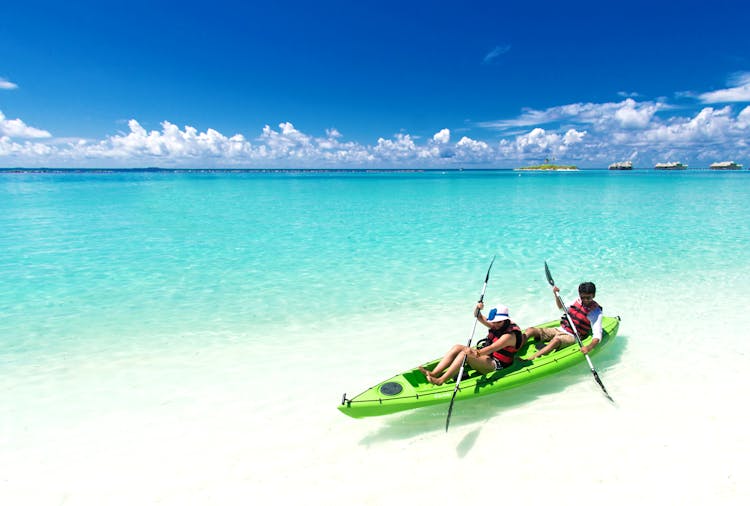 Two People Riding Green Kayak On Sea