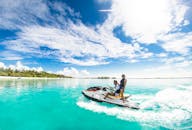 一对夫妇在马尔代夫清澈的海水中，迎着明亮的天空，享受激动人心的水上摩托艇之旅