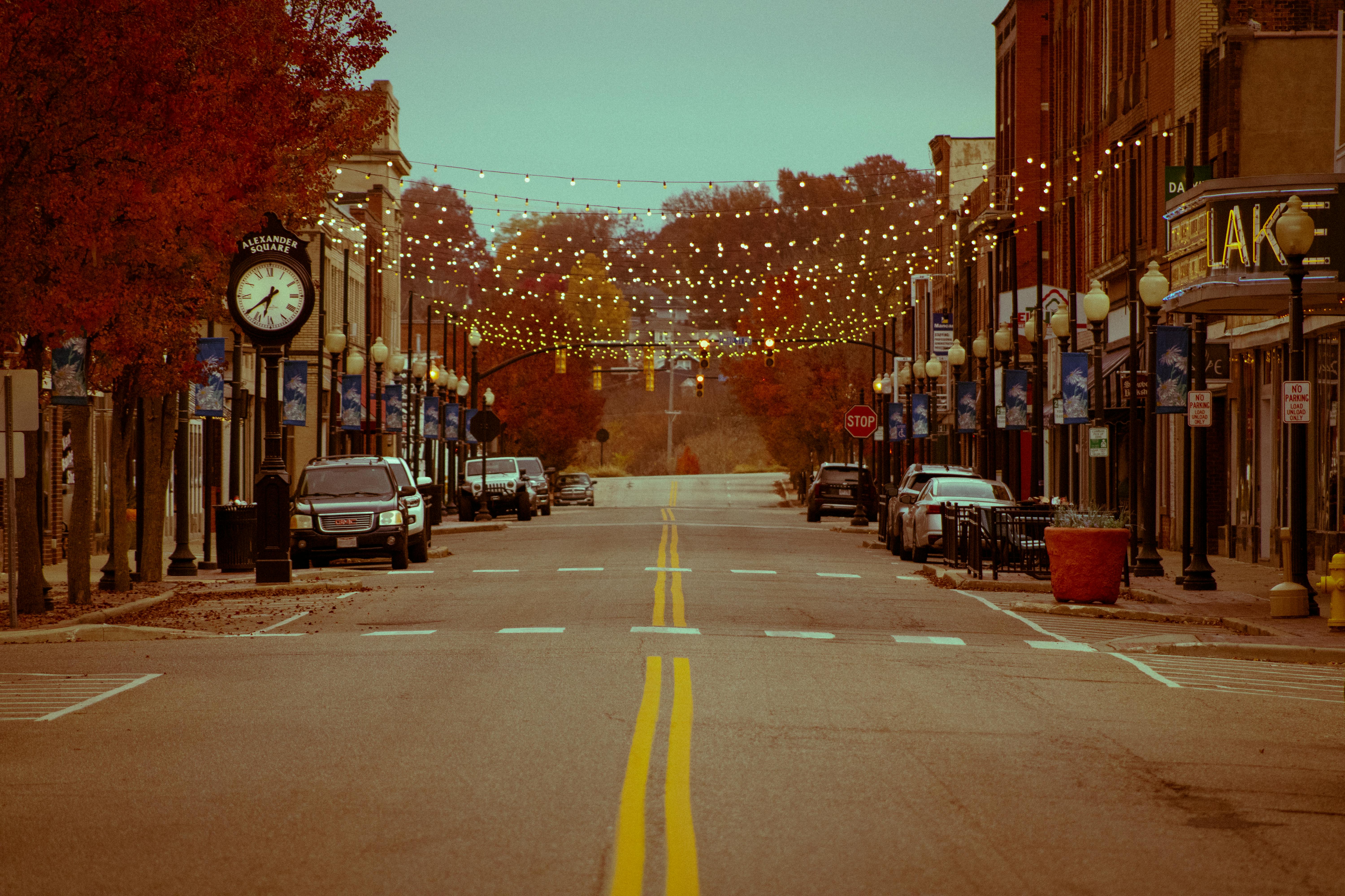 A nostalgic downtown street scene adorned with string lights in fall, creating a cozy atmosphere.