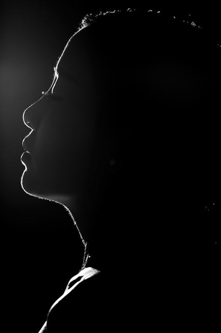 Elegant black and white silhouette portrait of a woman's profile with dramatic lighting.