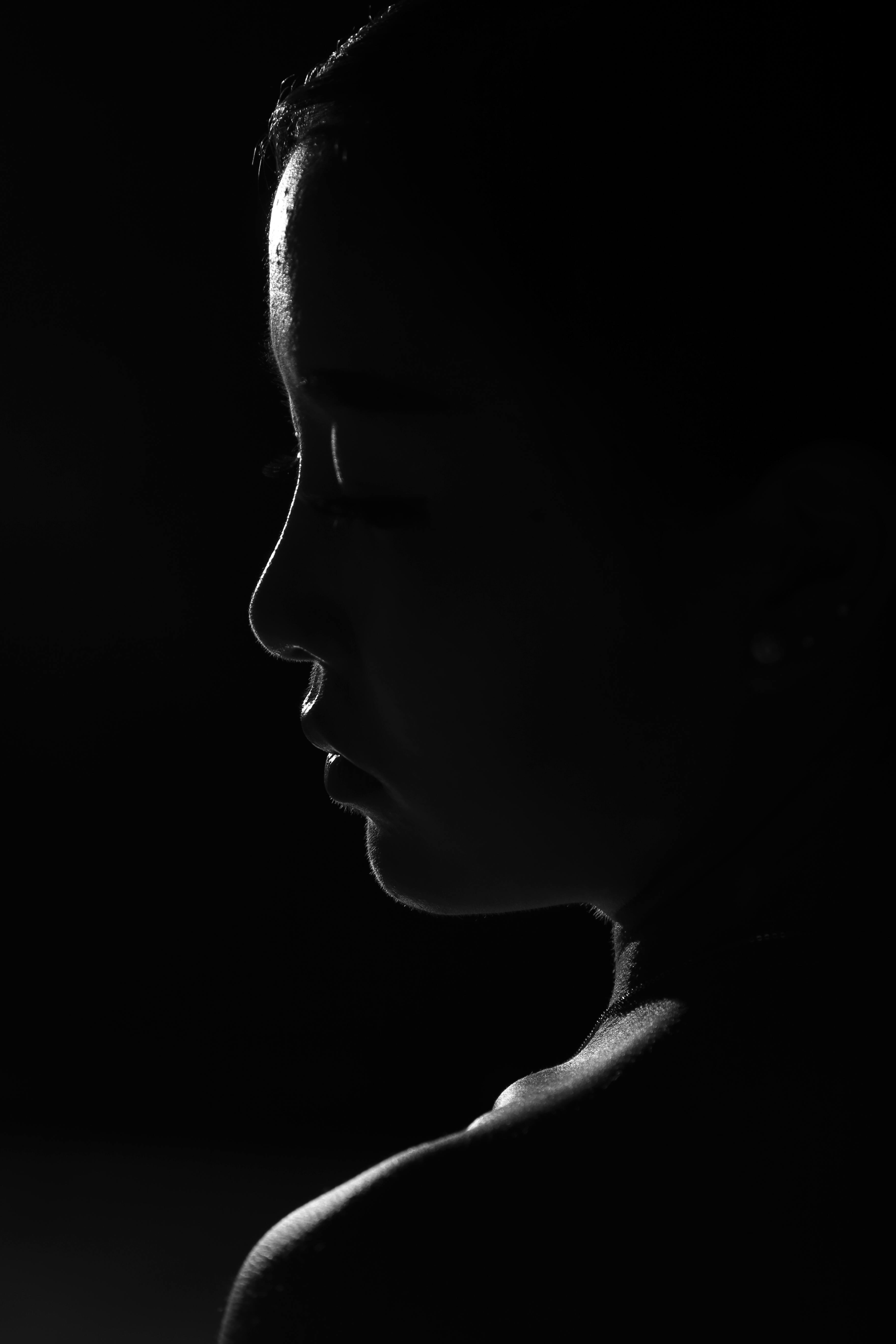 A powerful black and white silhouette portrait of a woman's profile, emphasizing light and shadow.