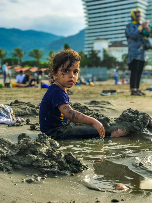 Girl Playing with Sand at the Beach