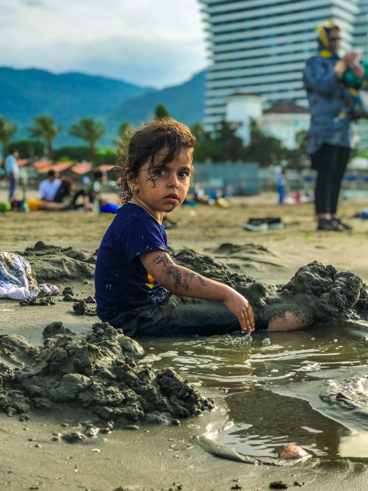 Girl Playing With Sand At The Beach