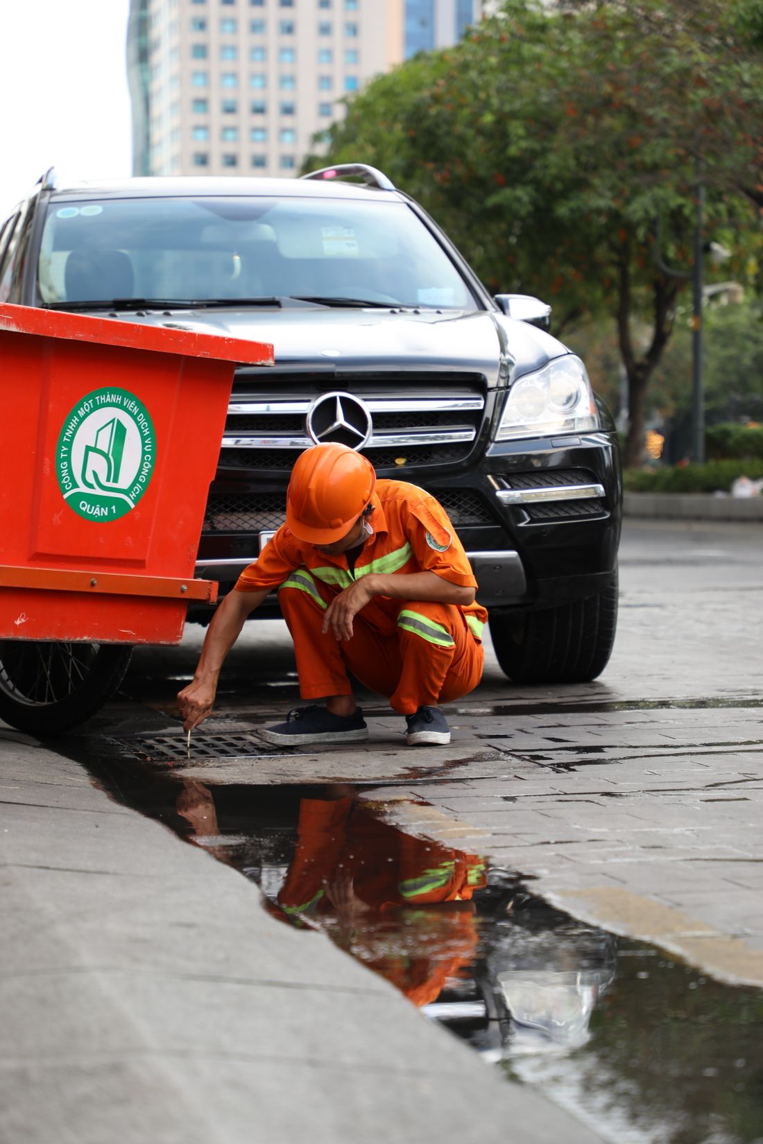 Plumber operating sewer camera inspection equipment at an outdoor drain access