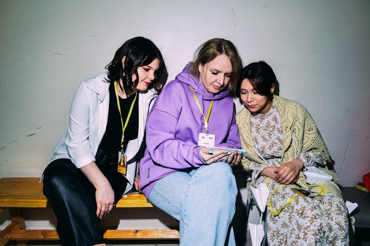 A Group Of Women Watching On A Cell Phone