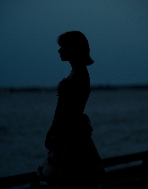Silhouette of a woman standing by the waterfront at twilight in Toronto, Canada.