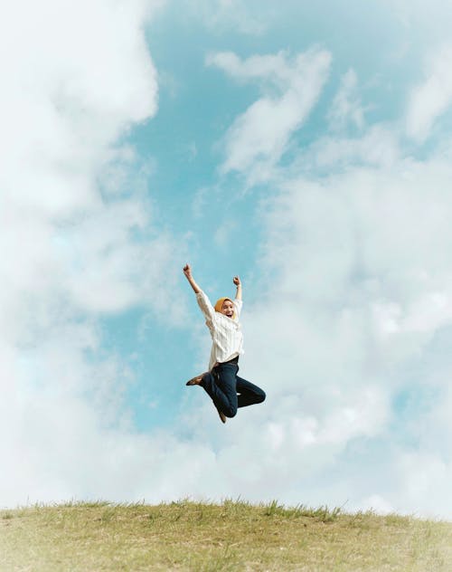 Free Person Jumping On Air With Clouds Background Stock Photo