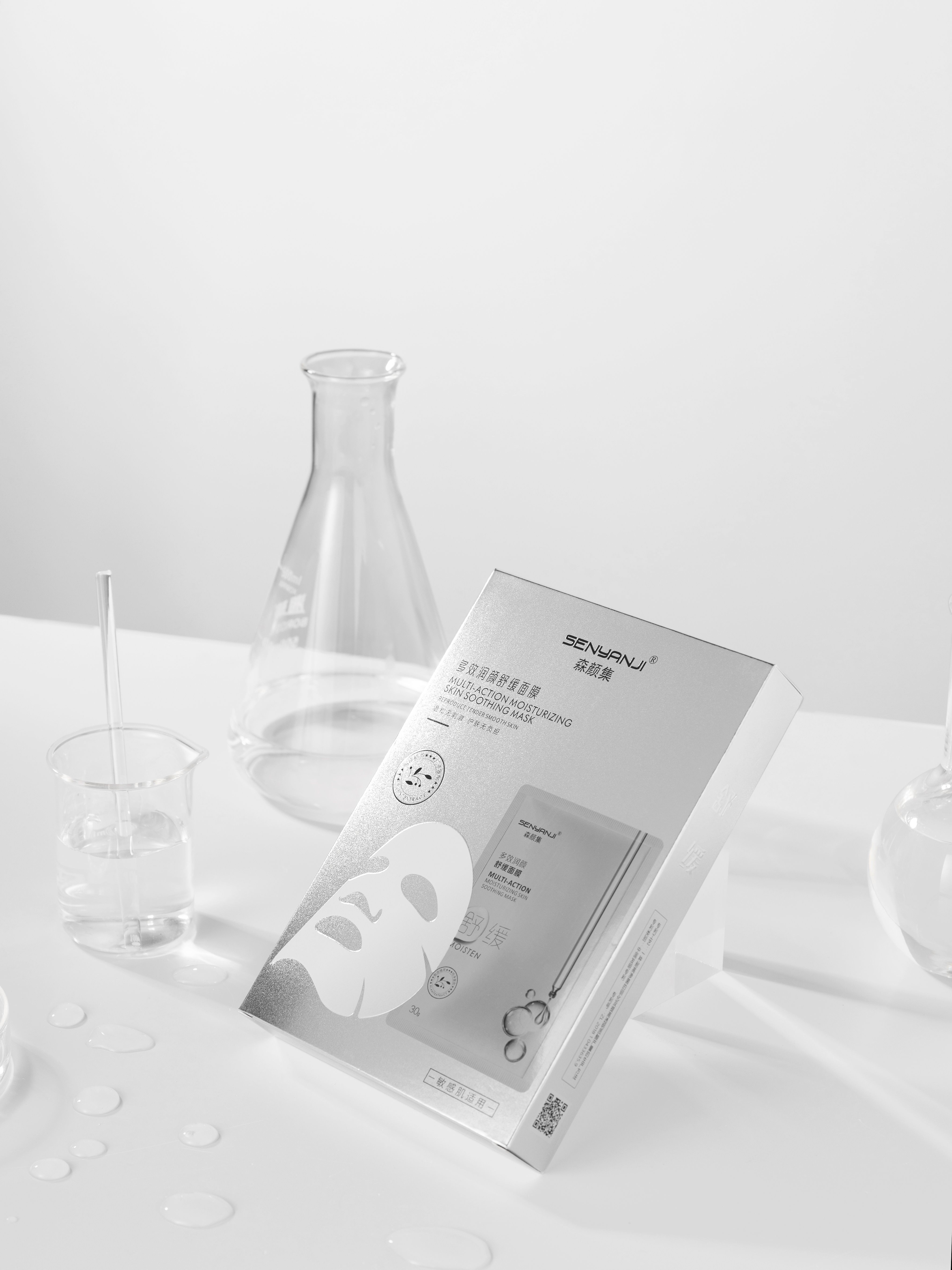 Sleek beauty mask packaging with laboratory glassware in a modern, minimalist composition.