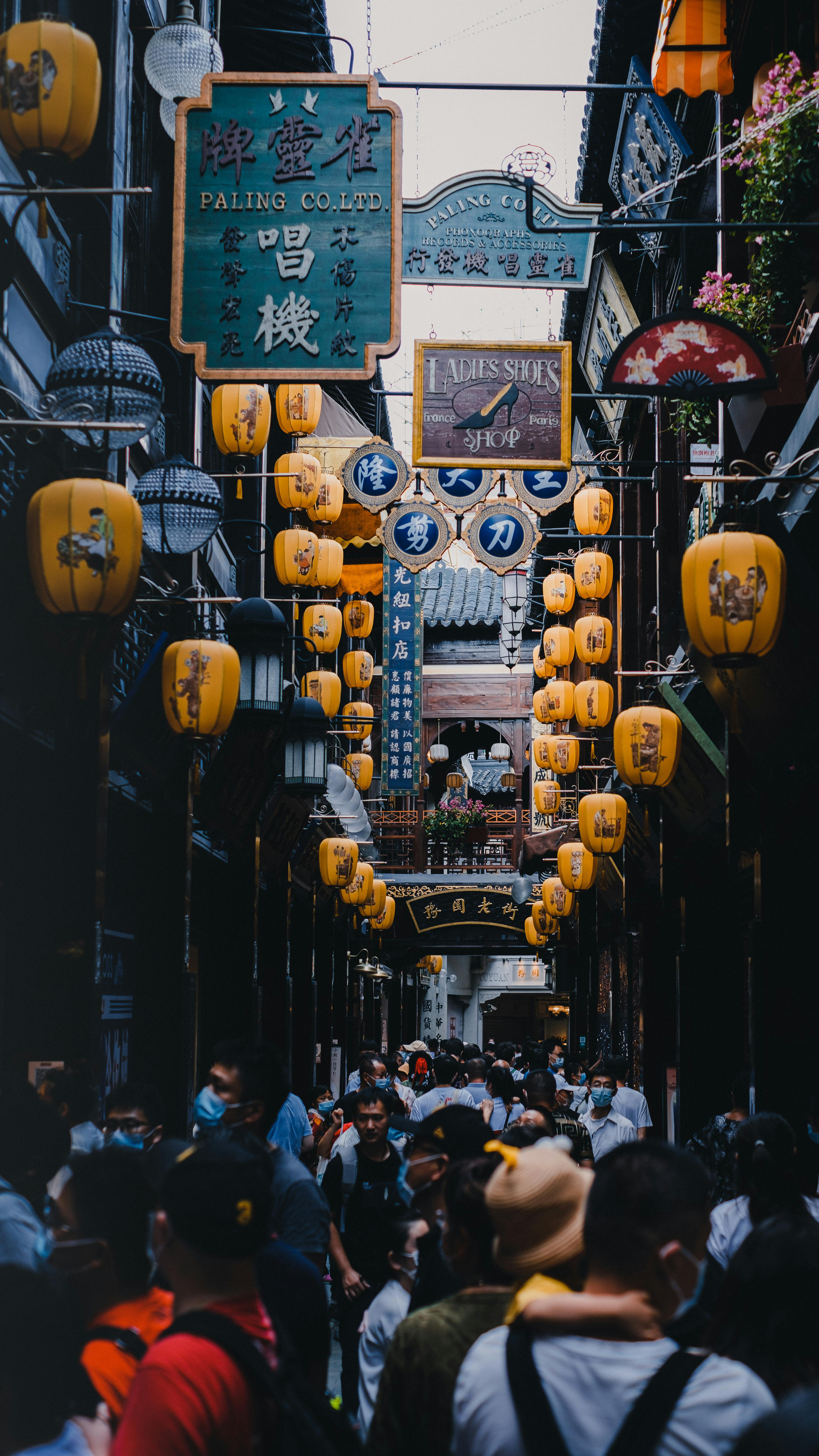 Vibrant street scene with people and Chinese lanterns in Shanghai, China, showcasing urban life.
