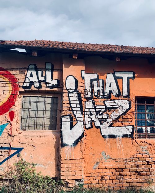 Free Colorful graffiti art on an abandoned brick building facade with vibrant street art expressions. Stock Photo