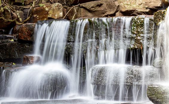A serene long exposure of a natural waterfall cascading over rocks in Durban, South Africa.
