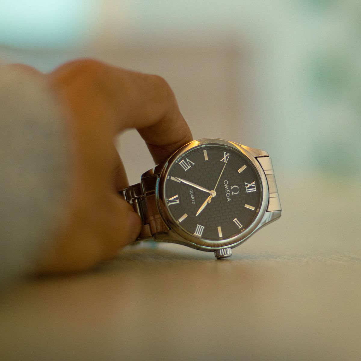 Reloj Omega vintage con numerales romanos sujeto en la mano