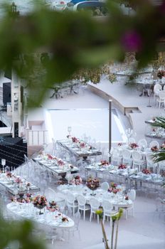 Aerial view of a stylish wedding reception setup outdoors with white tables and floral decor.