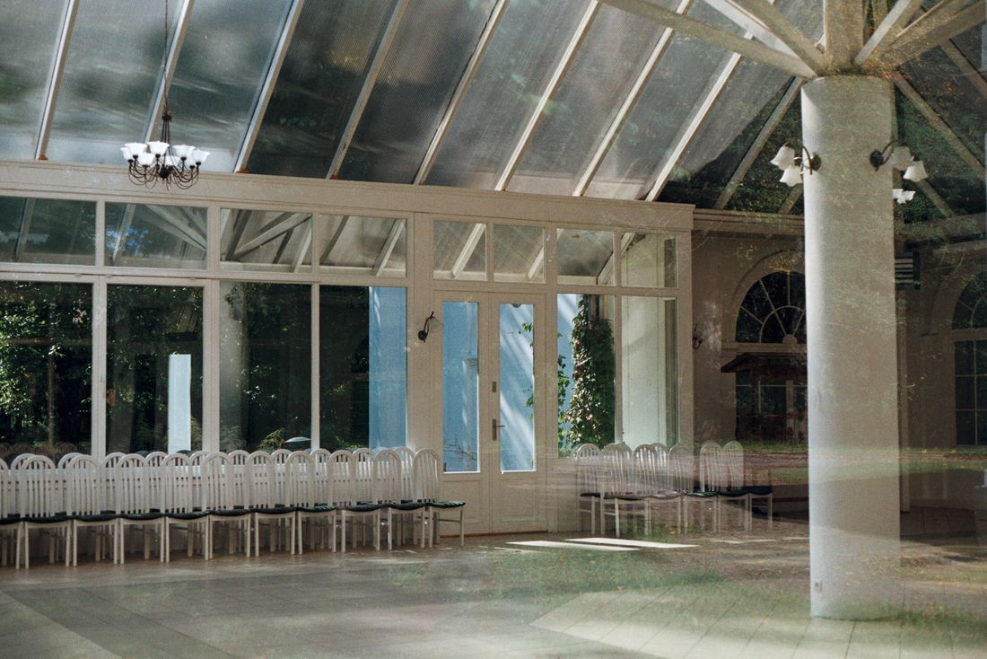 Spacious conservatory interior with a glass ceiling and elegant seating