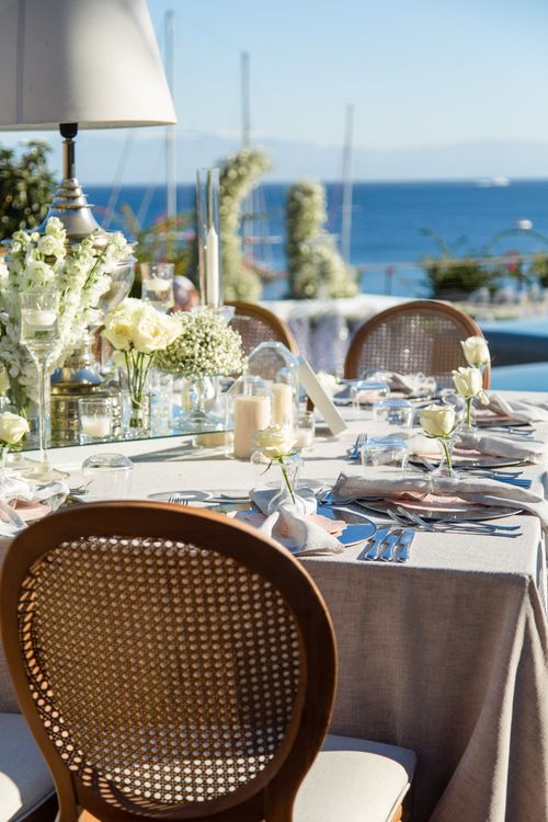 Free Beautifully arranged outdoor wedding reception table with a sea view. Stock Photo