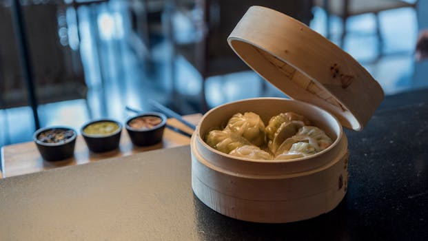 竹篮里热气腾腾的点心饺子特写，配上了酱汁