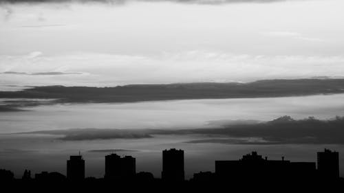 gratis Silhouet Van Gebouwen Onder Grijze Wolken Stockfoto